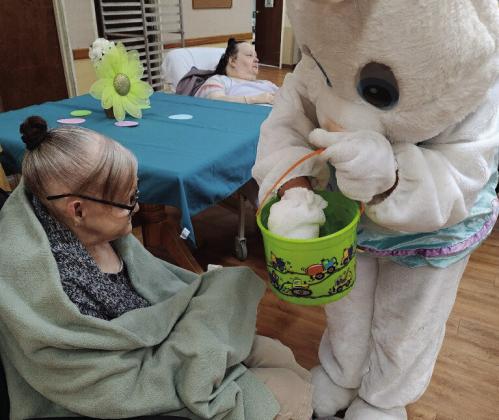 The Easter bunny made several stops around town this past weekend. Betty Capps, a resident at Paradigm at the Pines in Silsbee, takes her pick of candy from the Easter basket. Courtesy Photos