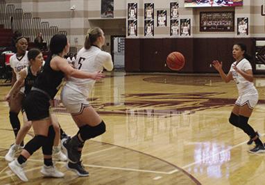 Jenna Warden flips a pass to an open Monica Bottley as she moves up to the three point line in preparation for an open shot.Warden has a couple of LCM defenders attempting to keep her out of the lane. Dan Eakin photo