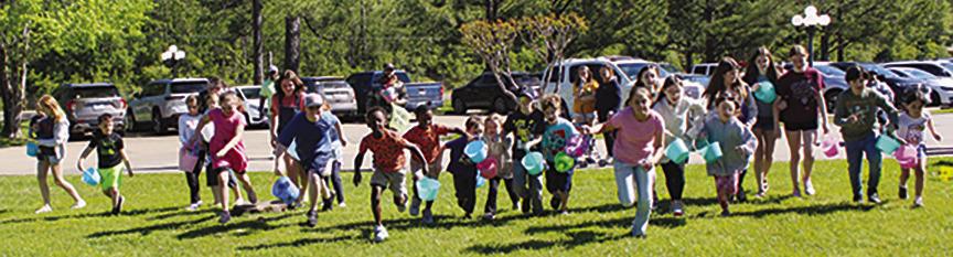 A long line of children,most with Easter buckets,race toward the area where the Easter eggs are waiting to be picked up adjacent to Paradigm at the Pines last Friday morning.